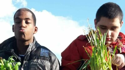 Twee jongeren met een beperking die voor plantjes zorgen